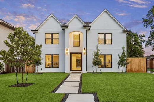 exterior of a white house with the lights on inside