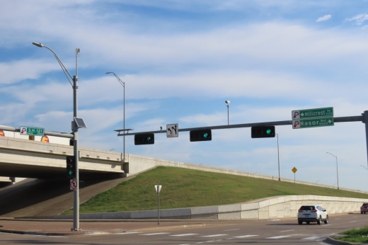 The intersection at SH 121 and Rasor Boulevard against a blue sky.