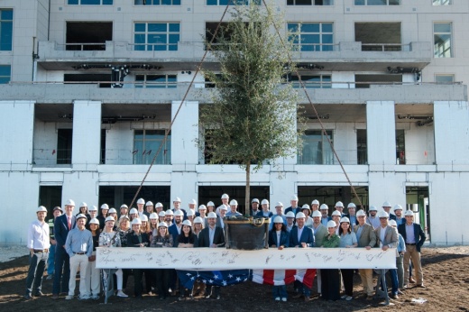 a large group stands in front of a building construction site