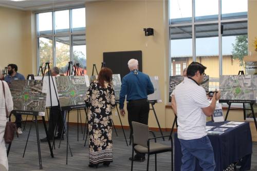 Pictured are people looking at various signs with roundabout information.