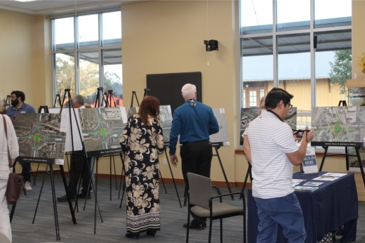 Pictured are people looking at various signs with roundabout information.