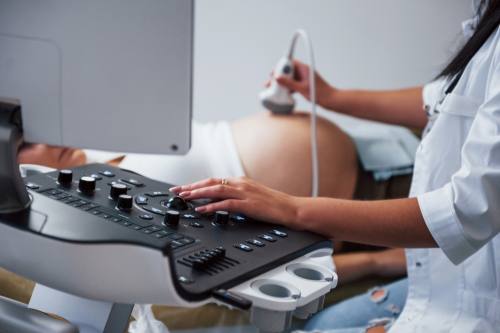 doctor performing an ultrasound on a pregnant patient