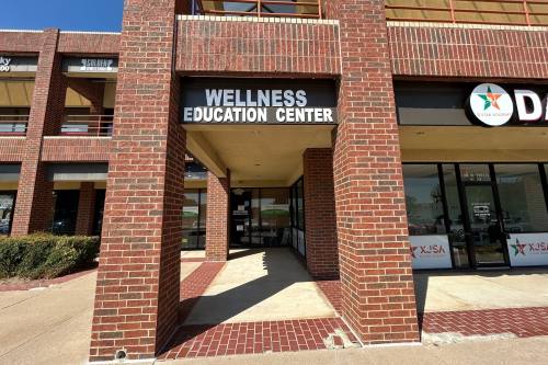 Exterior of strip center with Wellness Education Center signage.
