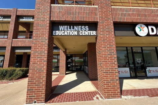 Exterior of strip center with Wellness Education Center signage.