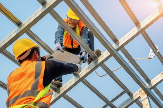 A photo of construction workers installing a new roof at a construction site.