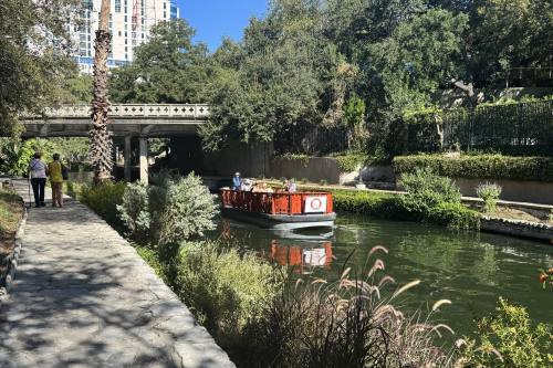 a barge floats down a river with greenery and trees surrounding it
