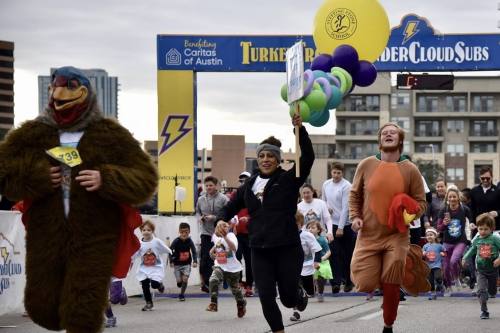 People dressed as turkeys run in a previous turkey trot.