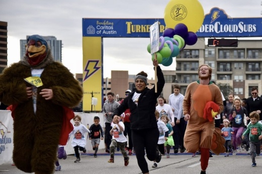 People dressed as turkeys run in a previous turkey trot.