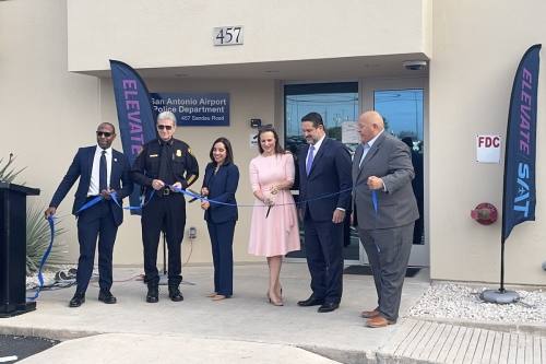 people cut a ribbon in front of a building