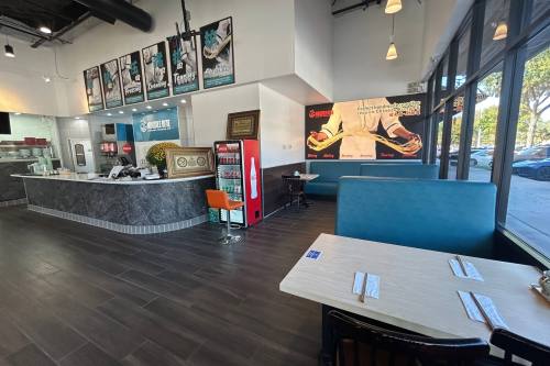 Interior of a restaurant featuring artwork depicting a person holding noodles.