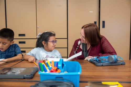 Student and teacher at Kaiser Elementary working on a paper