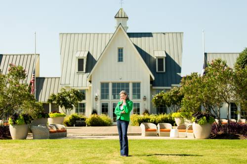 Realtor posing in front of home for sale in Dallas