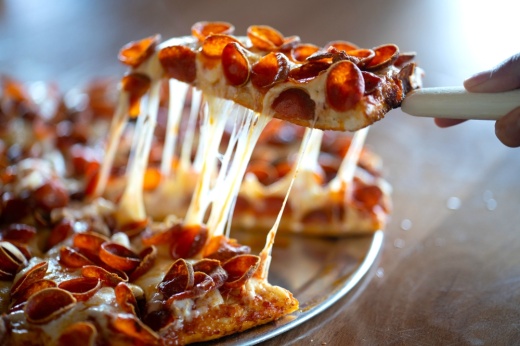 Slice of pizza with a cheese pull