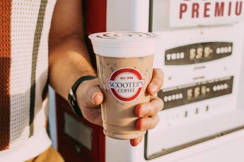 a hand holding an iced coffee from scooters coffee