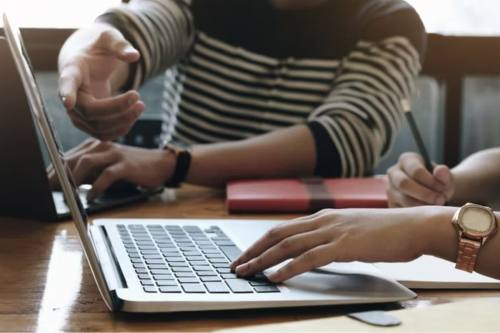 hands type on a computer