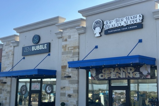 Two stores, a tea shop and a hair salon, are seen in a shopping center on a sunny day in Cibolo, Texas.
