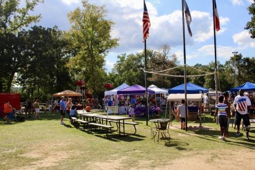 tents and tables set up in a grassy area outside