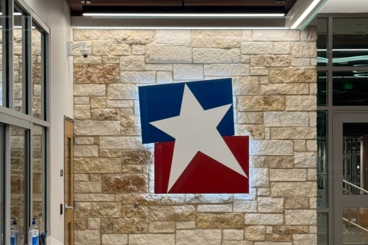 a school district logo of a star with red and blue in the background is on a wall