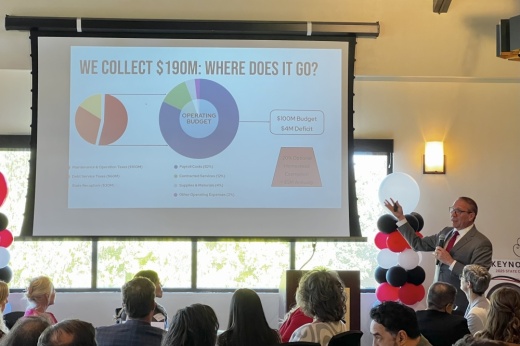 man pointing to slide with budget information