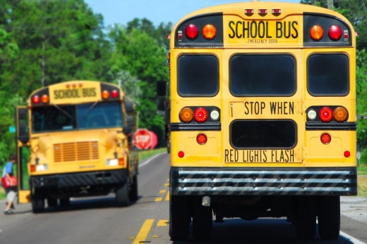 school buses pick up kids on a road