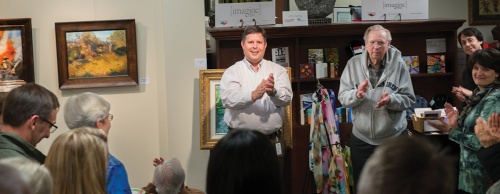 Scot Wilkinson (center), executive director for the arts for the city of Round Rock, celebrates the artists of the Cordovan Art School, whose works are on display at ArtSpace.