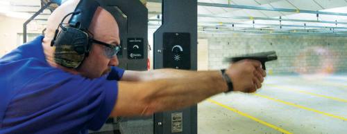 Hood demonstrates proper firearm grip and stance at Shady Oaks Gun Range in Cedar Park.