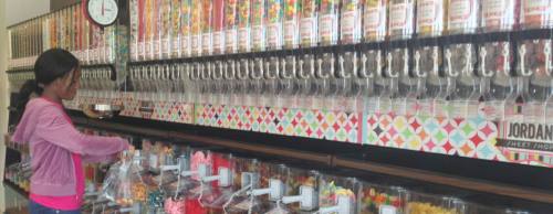 Sales associate Fola Falegan fills up a treat bag from one of the candy storeu2019s bulk bins.