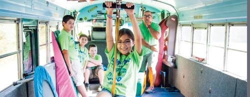 Skylar Gonzalez uses a zip line to cross the length of a Giggle Bus.