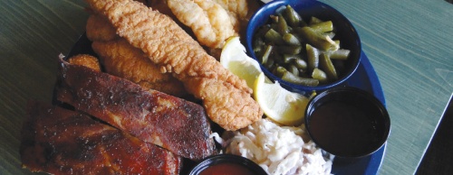 The Cherry Creek Trio ($13.99) comes with two catfish fillets, three shrimp, two pork ribs and two sides. The two sides pictured are green beans and coleslaw. The ribs are smoked daily, co-owner Danny Lenertz said. 