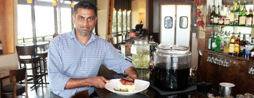 Anil Prasad, Drixu2019s general manager, poses with the restaurantu2019s sweet and tangy pork chops ($20).