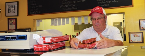 Ronnie Veron prepares stuffed pork chops for longtime customer Elton Williams. 