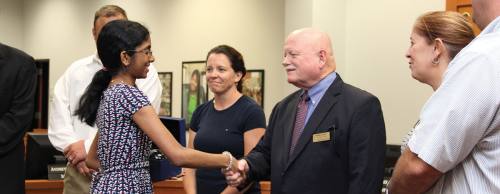 Gant congratulates a student during a PISD school board meeting.
