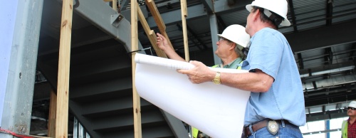 Permitting and construction of buildings in Austin could be affected by a resolution on Austin City Council's agenda Sept. 1. From left: Hal Faulk, superintendent with Flynn Construction Inc., talks with city of Austin Inspector John Brown at a building under construction on Rialto Blvd. in May 2014 in Southwest Austin.