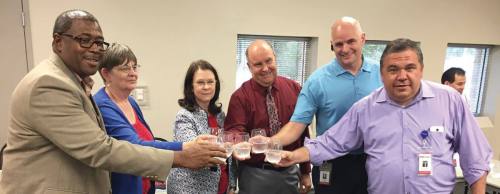 From left: Buda City Manager Kenneth Williams, Buda City Council Member Eileen Altmiller, San Marcos City Council Member Jane Hughson, Kyle City Council Member David Wilson, San Marcos City Manager Jared Miller and San Marcos Assistant City Manager Steve Parker celebrate after signing a water-sharing agreement July 27.