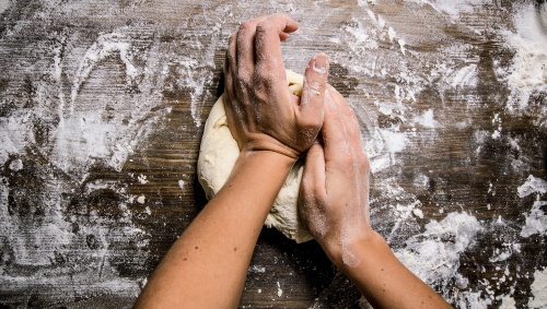 Preparation of the dough. Preparation of the dough the women's hands. On a wooden table.  Top view