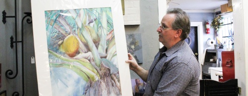 Richard Speer displays original watercolor art by Lana Williams at the gallery on Preston Avenue.
