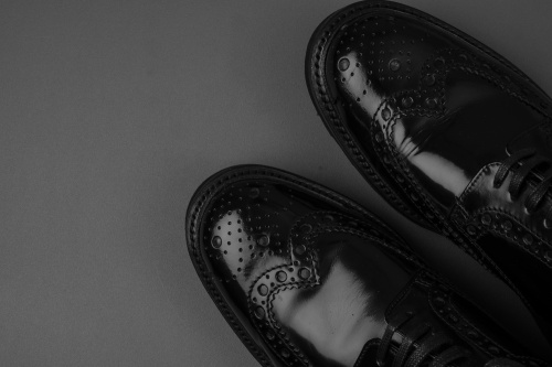 The pair of black leather shoes on a black background