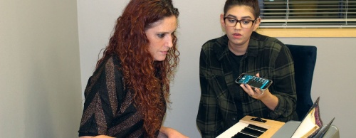 Sarah Kelly (left) helps a student with a song during Career Class.