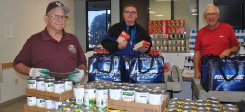 Volunteers at Northwest Assistance Ministries prepare canned and boxed food items in the food pantry.