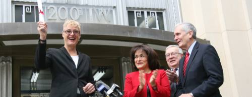 Travis County Judge Sarah Eckhardt (left) accepts the deed for the Austin Federal Courthouse, where the county intends to move its probate courts and county clerk services, she said.