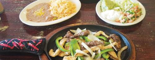 Beef and chicken fajitas are served in a sizzling skillet with onions and peppers, refried beans and rice, pico de gallo, guacamole and sour cream for $13.50.
