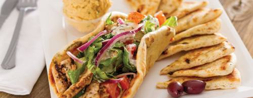 A chicken pita with lettuce, red onions and feta cheese.