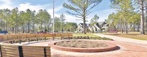 The Liberty Branch community in the Village of Creekside Park features a park area with benches surrounded by nature.