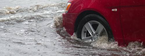 car rides in heavy rain on a flooded road