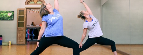 Studio Manager Elizabeth Adolphson (left) and Owner Salena Quilan-Shults demonstrate common yoga poses.