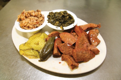 Beef links  ($14)  with sides of dirty rice and mustard greens