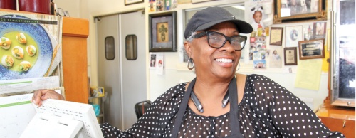 Janice Edwards greets customers behind the counter at The Greatest BBQ in Missouri City.