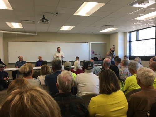 Municipal Utility District board member Rich Jakovac (standing) addressed a crowded room of residents at a public meeting Oct. 26. 