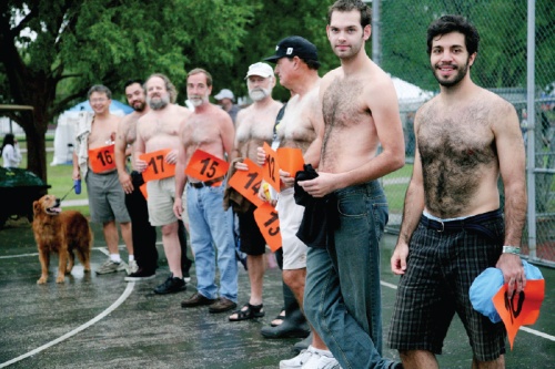 Hairy Man Competition contestants line up in front of a crowd and panel of judges made up of local elected officials.