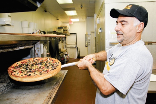 Owner Hani Barazi removes a pizza from the oven at Falbo Bros. Pizza in Sugar Land.n